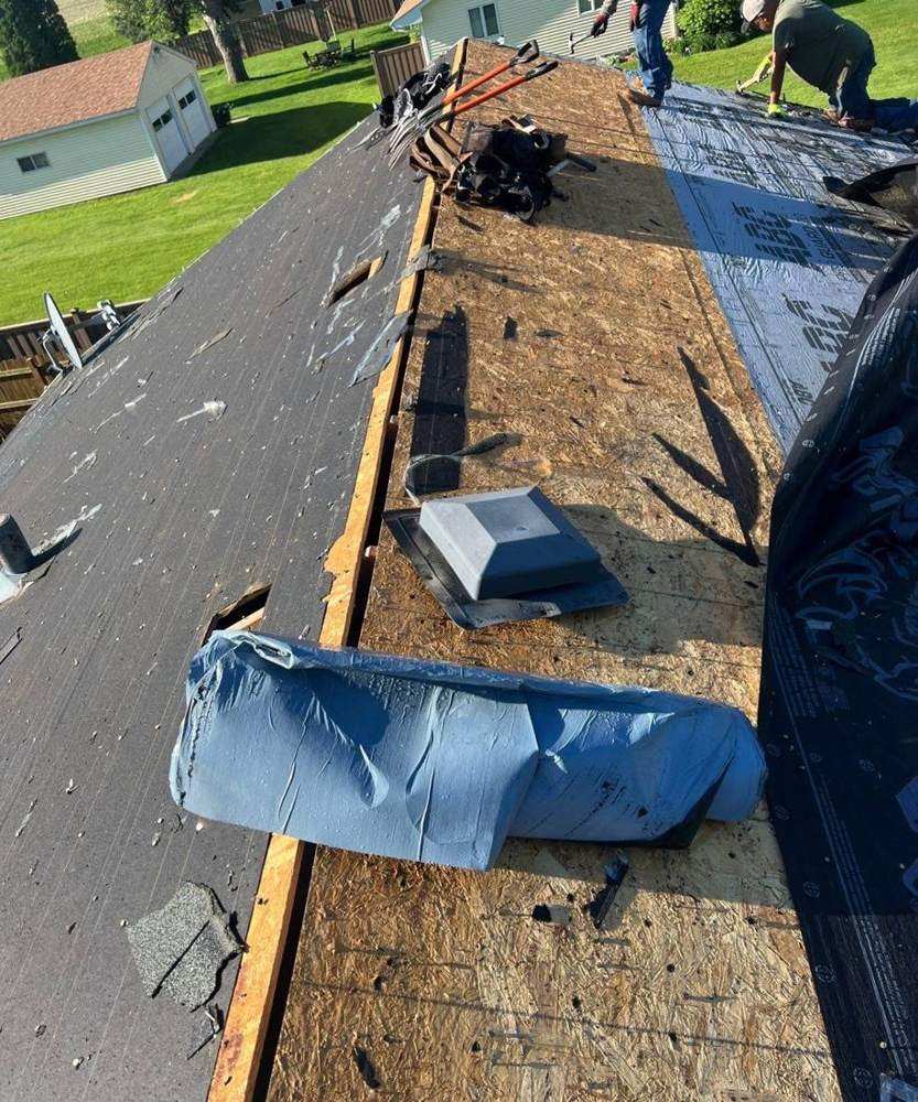 Torn-off Dennison roof deck with new synthetic underlayment rolled and ready, June 2024