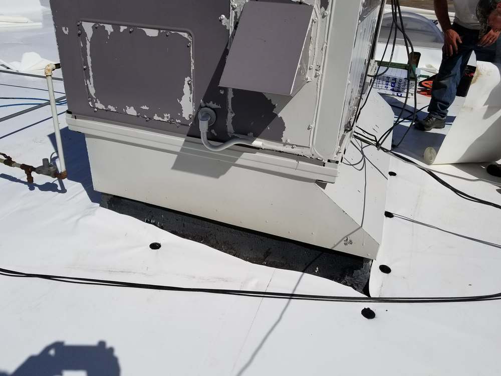Rooftop HVAC unit with its curb wrapped in new white PVC flashing on the Forest Lake Chrysler Jeep Dodge roof in Forest Lake, MN