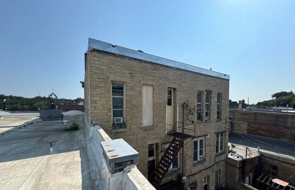 Stone commercial building and fire escape along a downtown Stillwater rooftop, September 2024