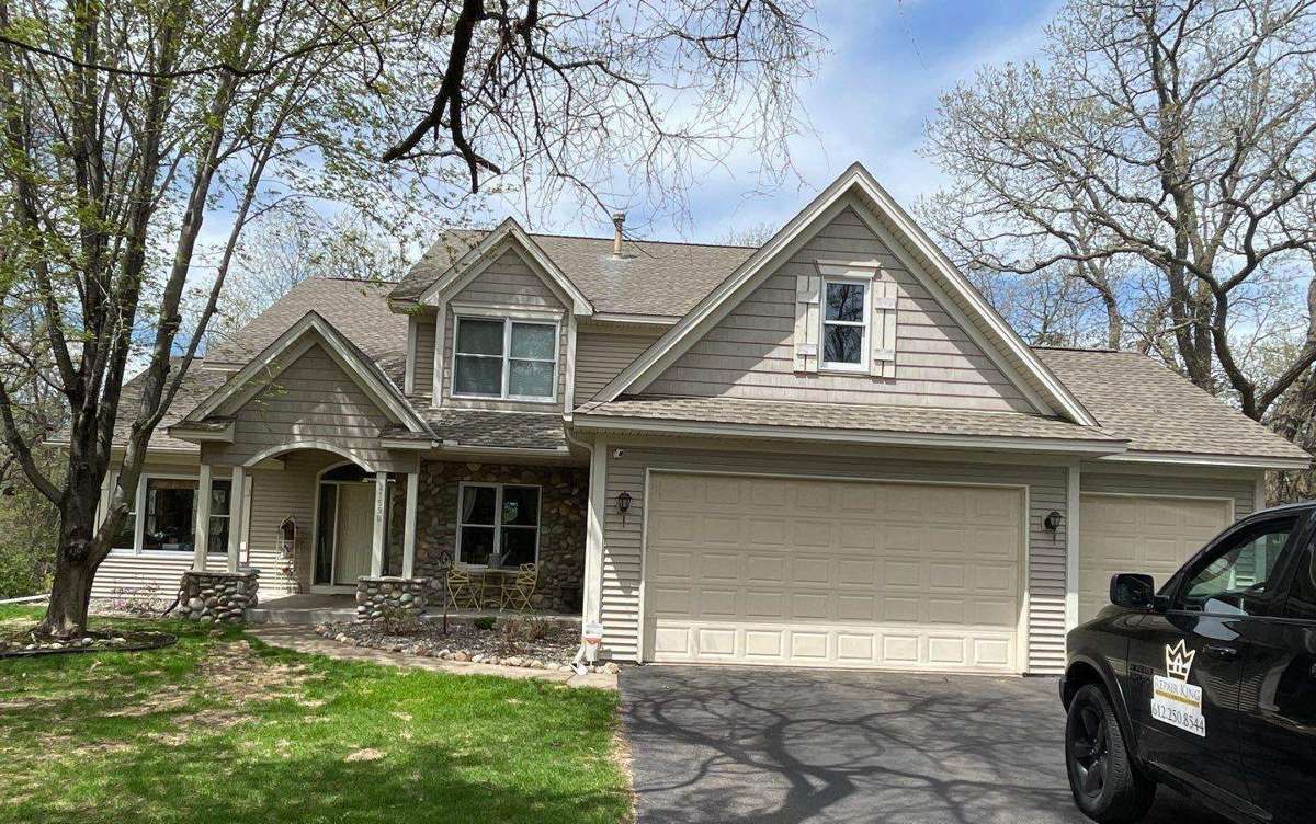 Two-story home in Big Lake, MN with a Repair King truck in the driveway, photographed during a roof project, May 2022