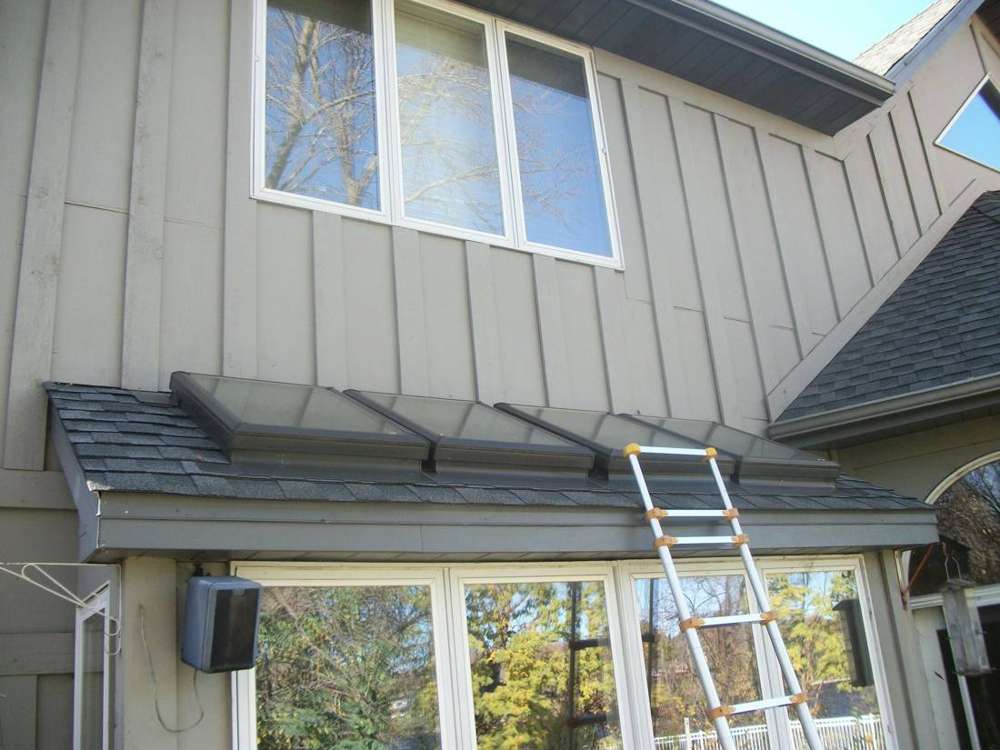 Bay window with a standing-seam metal roof below board-and-batten siding on a Champlin home, October 2017
