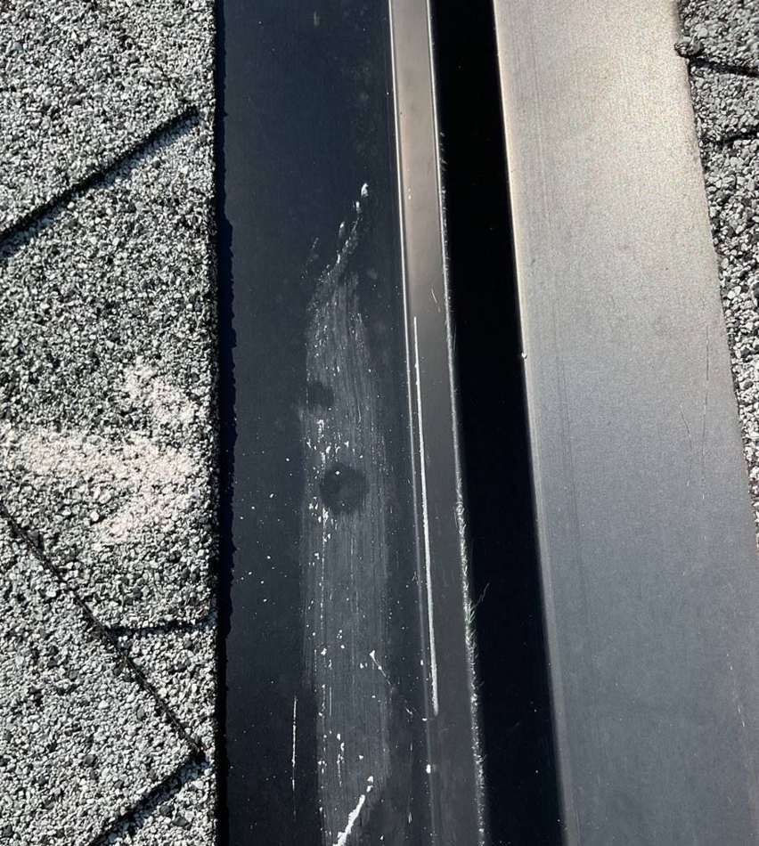 Dented ridge vent with chalk marks on a Blaine home, July 2023