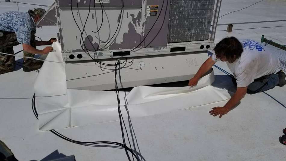 Repair King crew fitting white Duro-Last membrane around a rooftop unit on the Forest Lake Chrysler Jeep Dodge dealership in Forest Lake, MN, May 2017