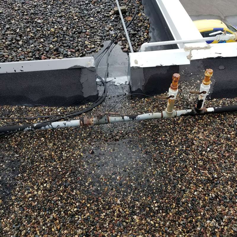 Pipes and conduit crossing the old gravel roof at the Forest Lake dealership, before the Duro-Last replacement