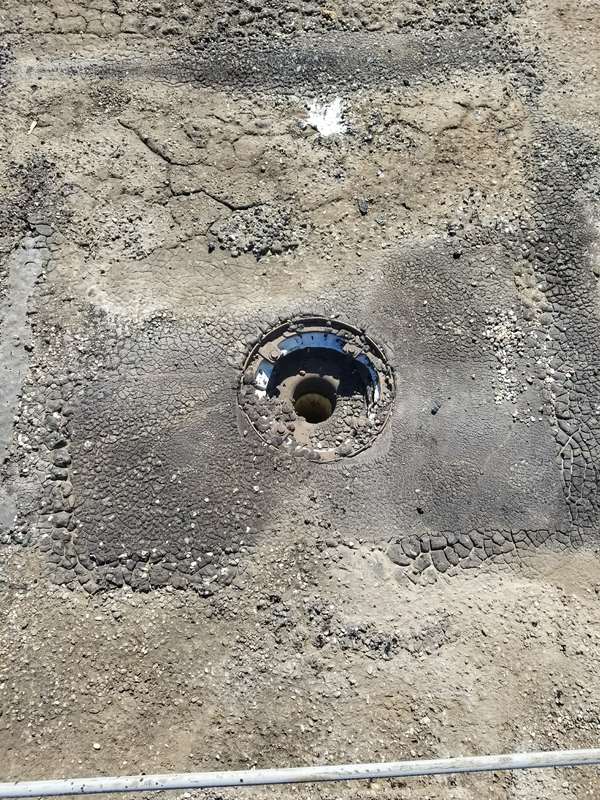 A roof drain on the stripped old roof surface at the Forest Lake dealership, ready for new insulation and membrane