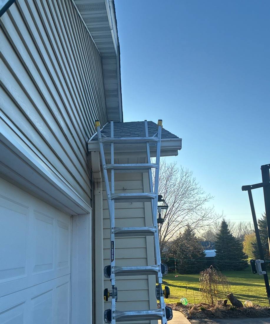 Ladder set on a garage roofline during a Rochester inspection, April 2026