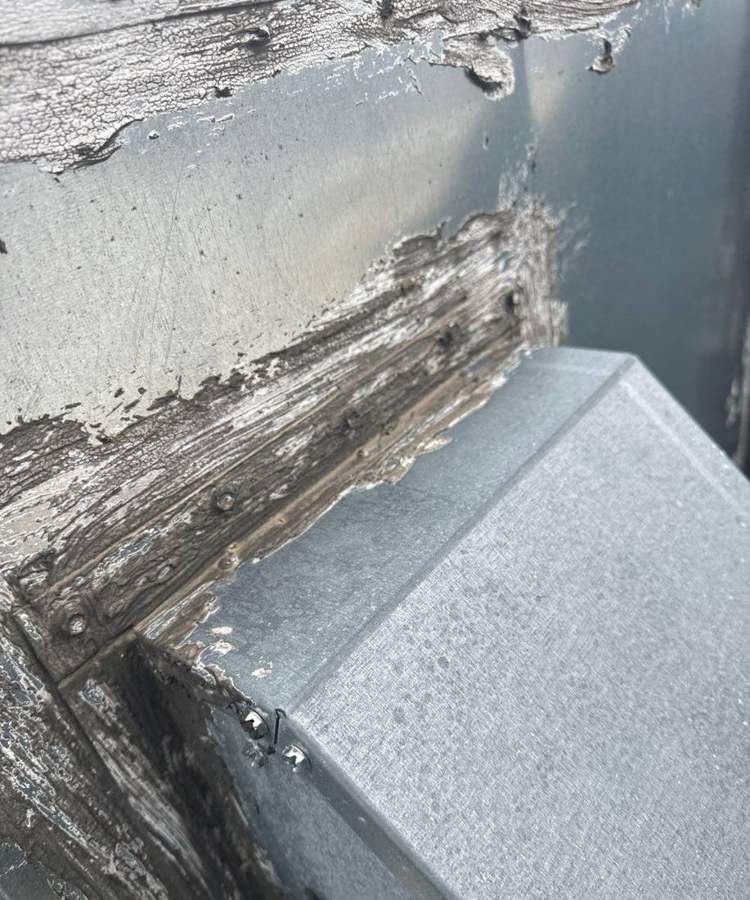 Split and peeling flashing at a rooftop duct curb on the old Bloomington Lincoln dealership roof in Bloomington, MN, July 2024
