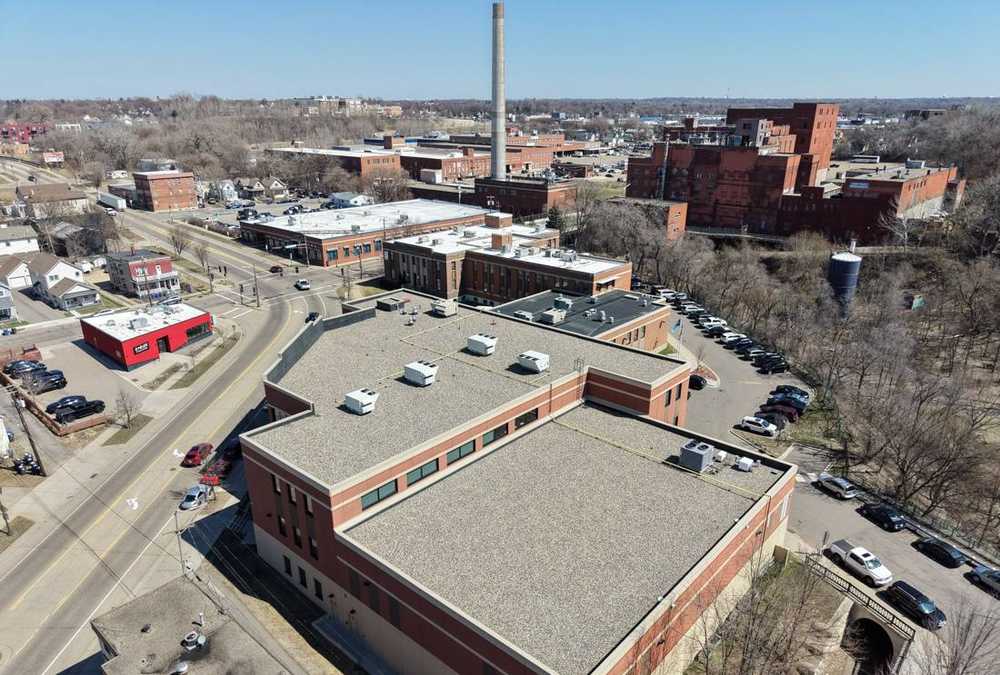 Drone view of Hope Community Academy on Payne Avenue with the downtown St. Paul skyline and Cathedral behind it, photographed by Repair King in April 2026