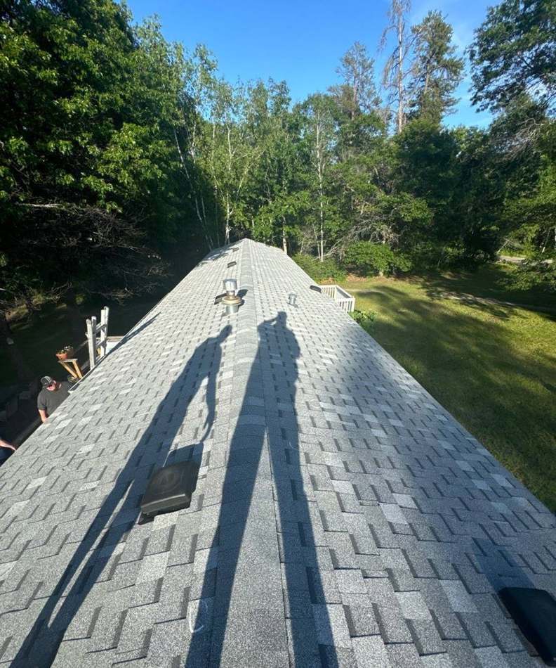 View down a Crosslake roof ridge toward the trees, June 2024