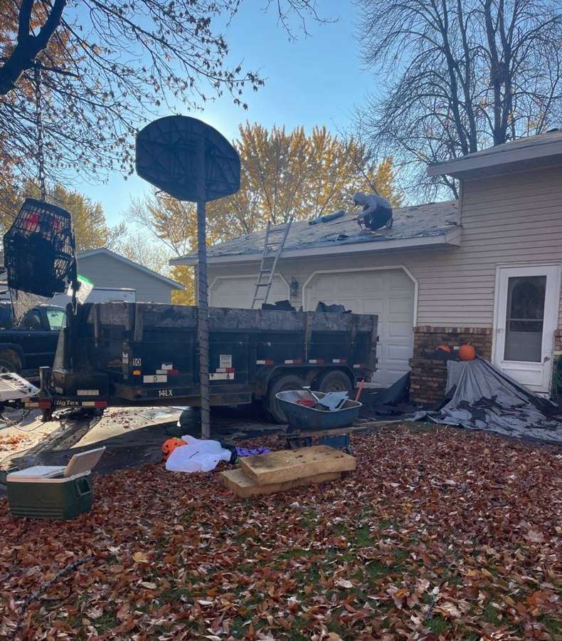 Dumpster and tarps set up for a roof tear-off on a Buffalo split-level, October 2021
