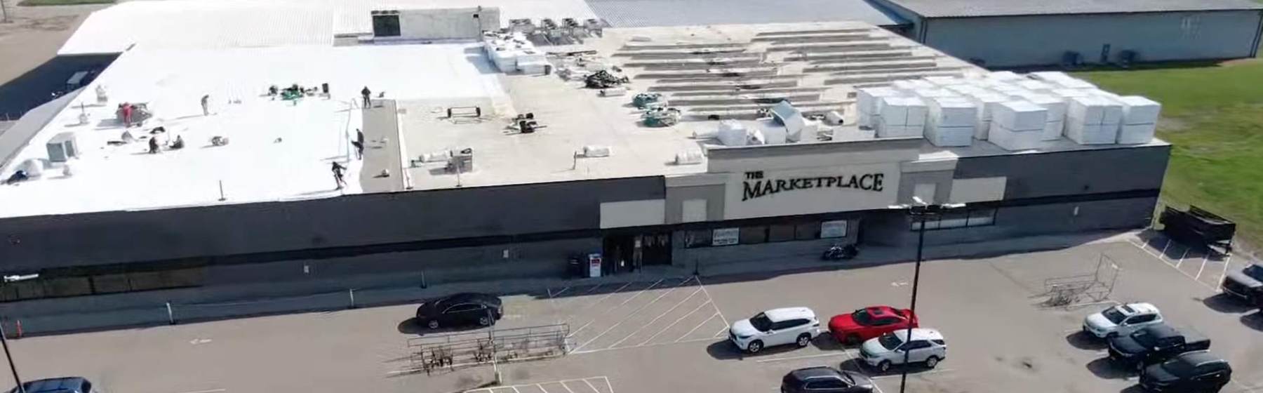 Aerial view of The Marketplace grocery store in Cokato, MN during Repair King's 2024 commercial roof project