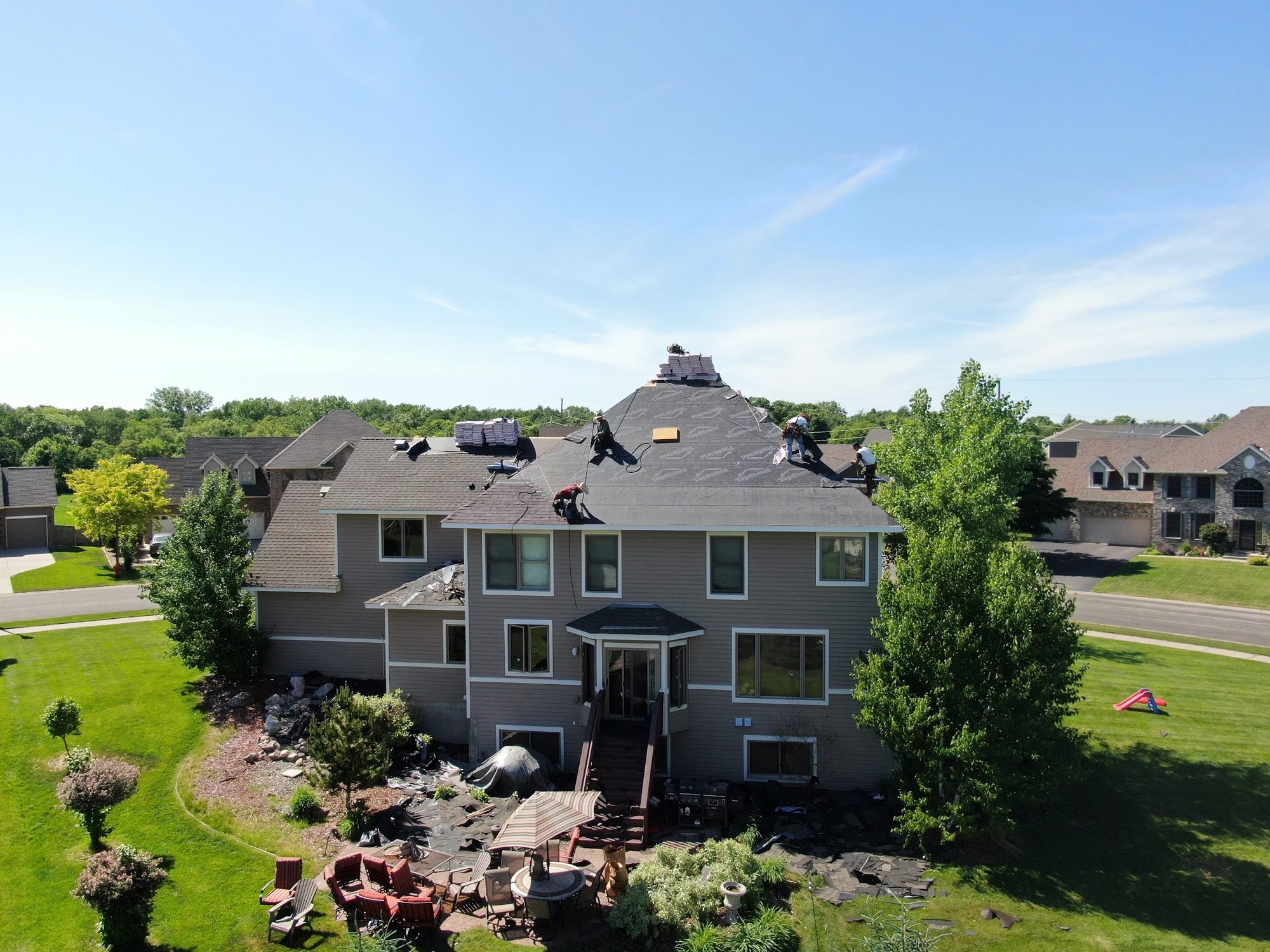 Repair King crew working on a two-story Twin Cities home with gray lap siding