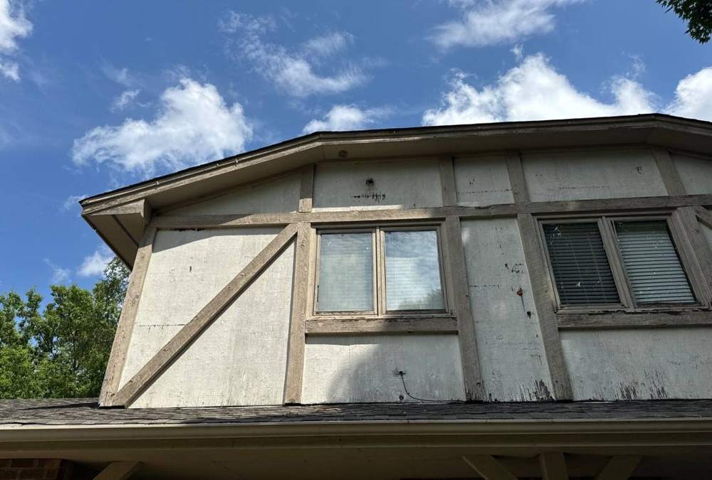 Weathered siding and trim on a Maple Grove home's upper gable, showing wear ahead of a roof and siding project, June 2024
