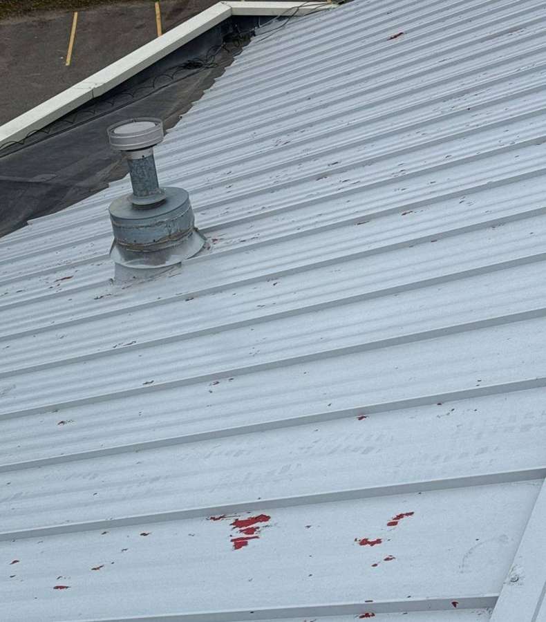 Chalk-marked hail hits on the metal roof panels of the Delano Dairy Queen, photographed by Repair King in November 2023