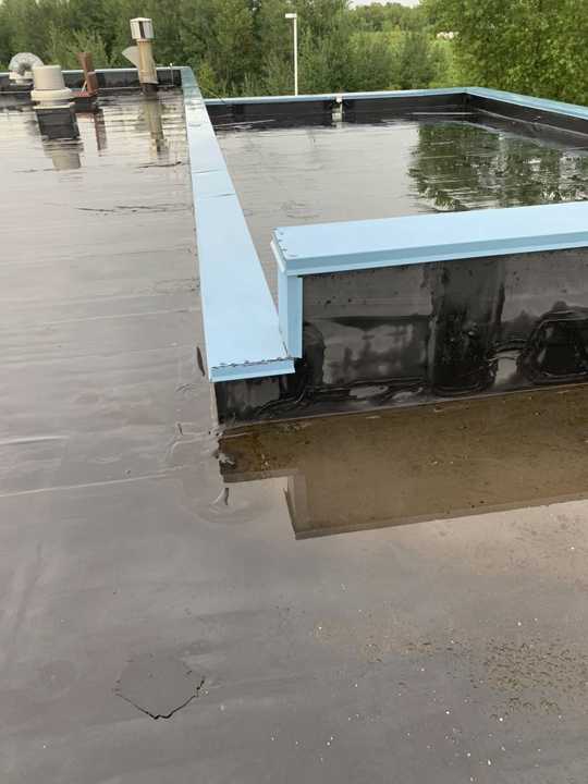 Standing water along the parapet on the flat roof at Eide Chrysler Dodge Jeep Ram in Pine City, MN, July 20, 2019