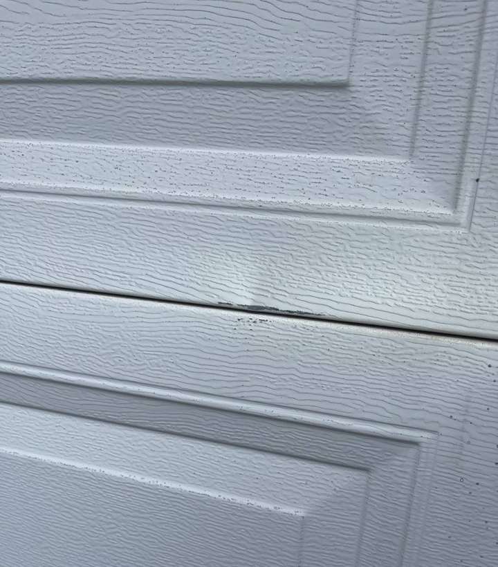 A creased garage door panel photographed at a Sauk Rapids home, October 2021