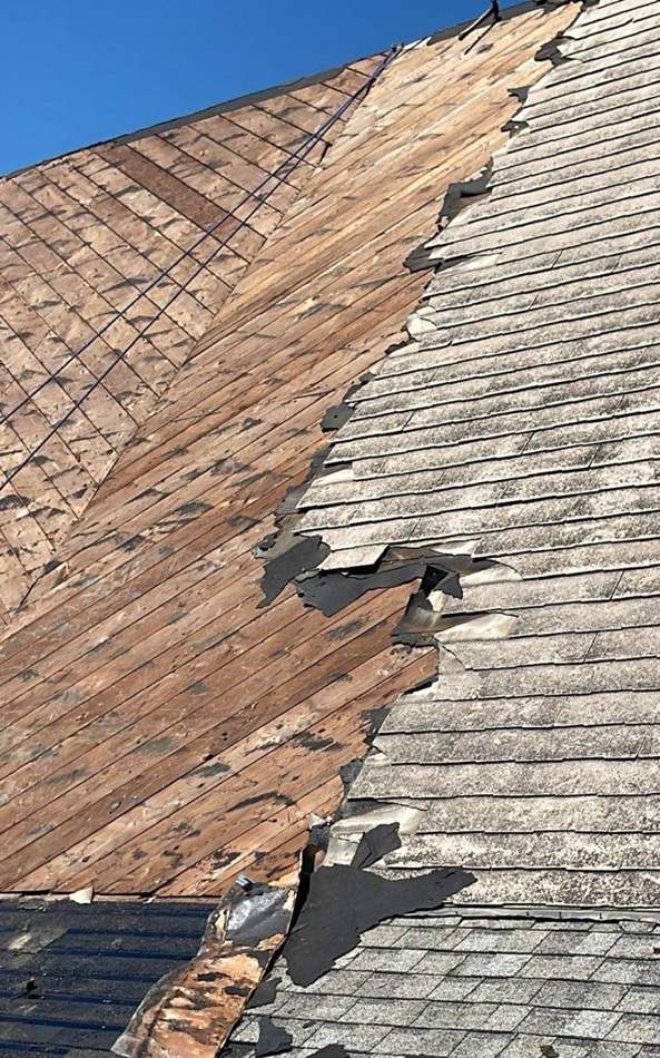 Torn-off shingles and exposed decking during the St. Paul Lutheran Church re-roof in St. James, July 2023