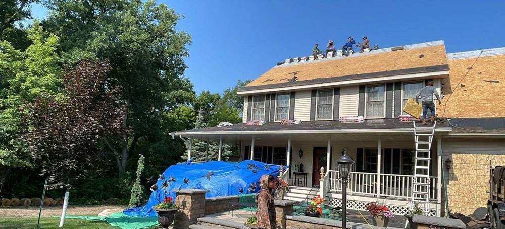 Repair King crew and crane re-roofing a two-story home in Wayzata, January 2024