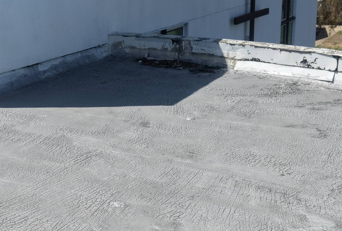 Flat roof membrane and rooftop cross window at a Lake City church, April 2026