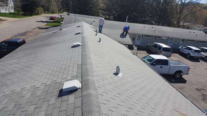 Walking the long shingle roof of Red Rock Lodge in Newport, with the parking lot below