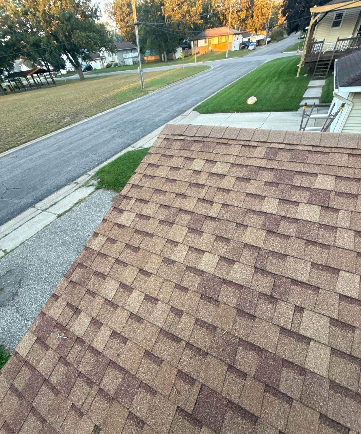Aerial view down a Newport, MN roof toward the street and neighborhood park, September 2025