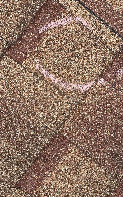 Chalk-circled hit on a brown architectural shingle, Finlayson motel roof, July 2023