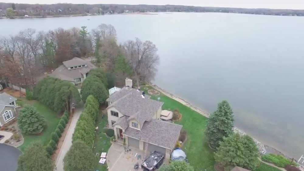 Lakefront home re-roof in Forest Lake, filmed from our drone with the lake behind it