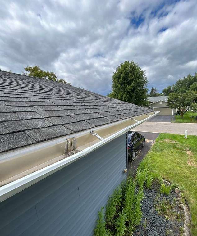 Gutter and shingle edge photographed during a hail inspection on an Apple Valley split-level, August 2025