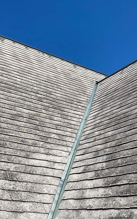 Metal valley flashing between two steep slopes of the original church roof in St. James, July 2023