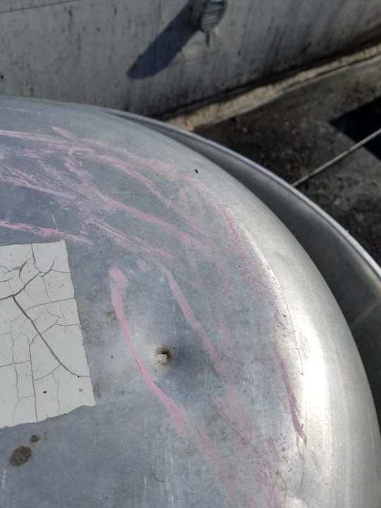 Chalk-marked dents on a metal exhaust fan cap on the Good Earth restaurant roof in Roseville