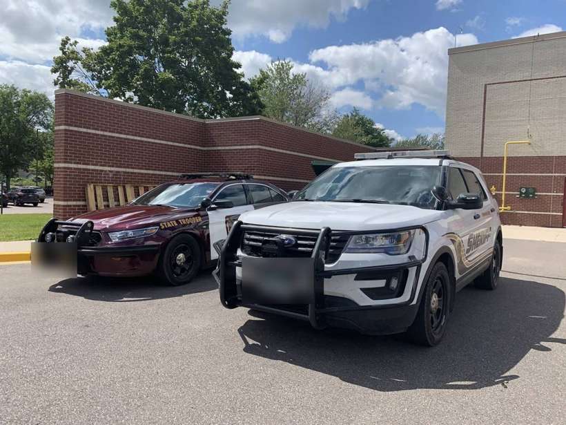 Minnesota State Trooper and sheriff's squad cars outside Talahi Elementary in St. Cloud, MN, during a community backpack giveaway
