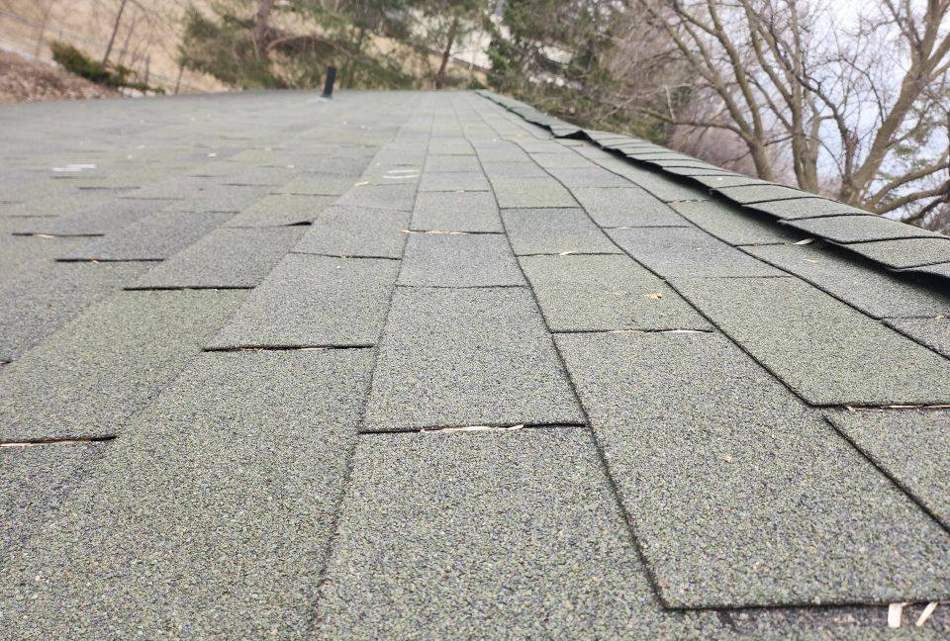 Lifted, cracked shingle tabs found on a Lonsdale roof during an inspection, April 2023