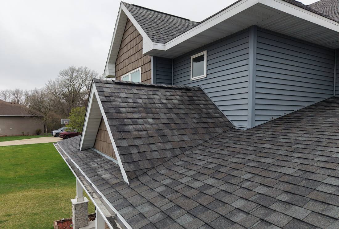 Porch and garage roof valleys meeting the second-story wall on a Red Wing, MN home, April 2026