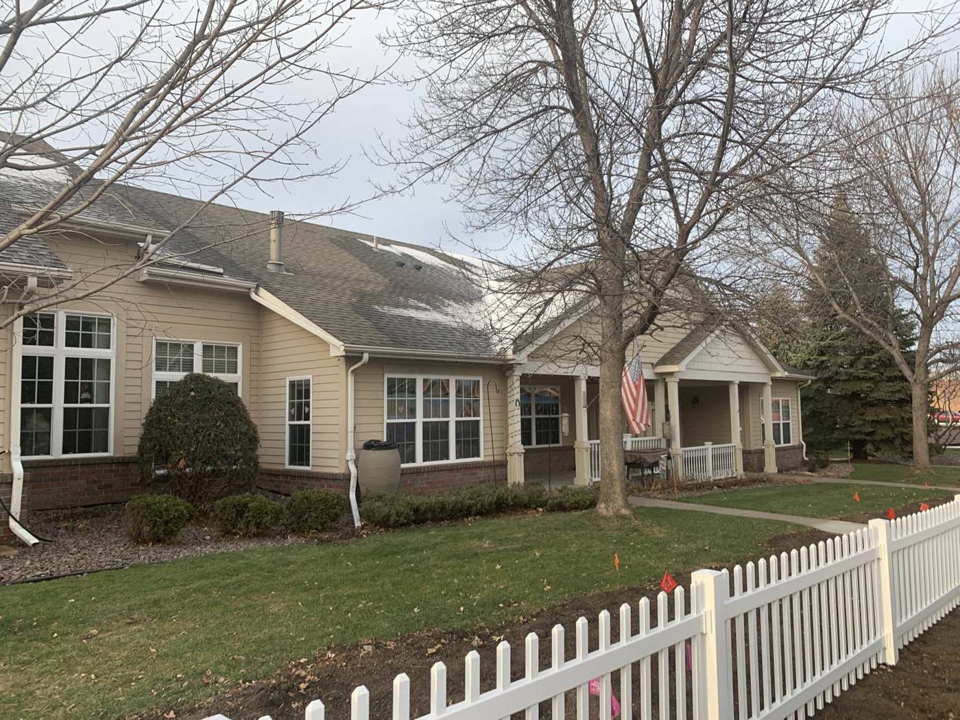 Single-level townhomes with a white picket fence at Penn Place in North St. Paul, MN, during a Repair King roof inspection