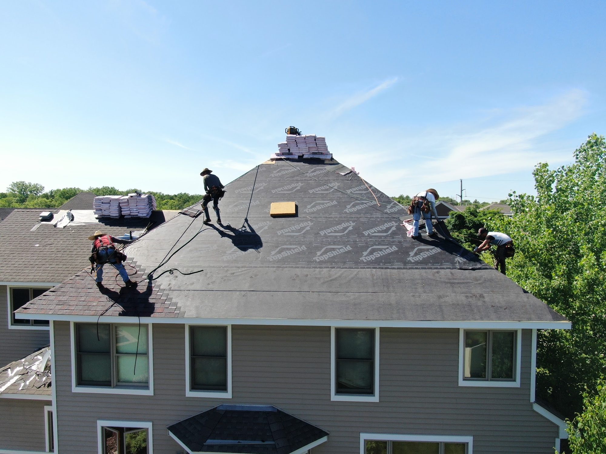 Repair King roofing crew tied off and installing a new shingle roof on a Twin Cities home