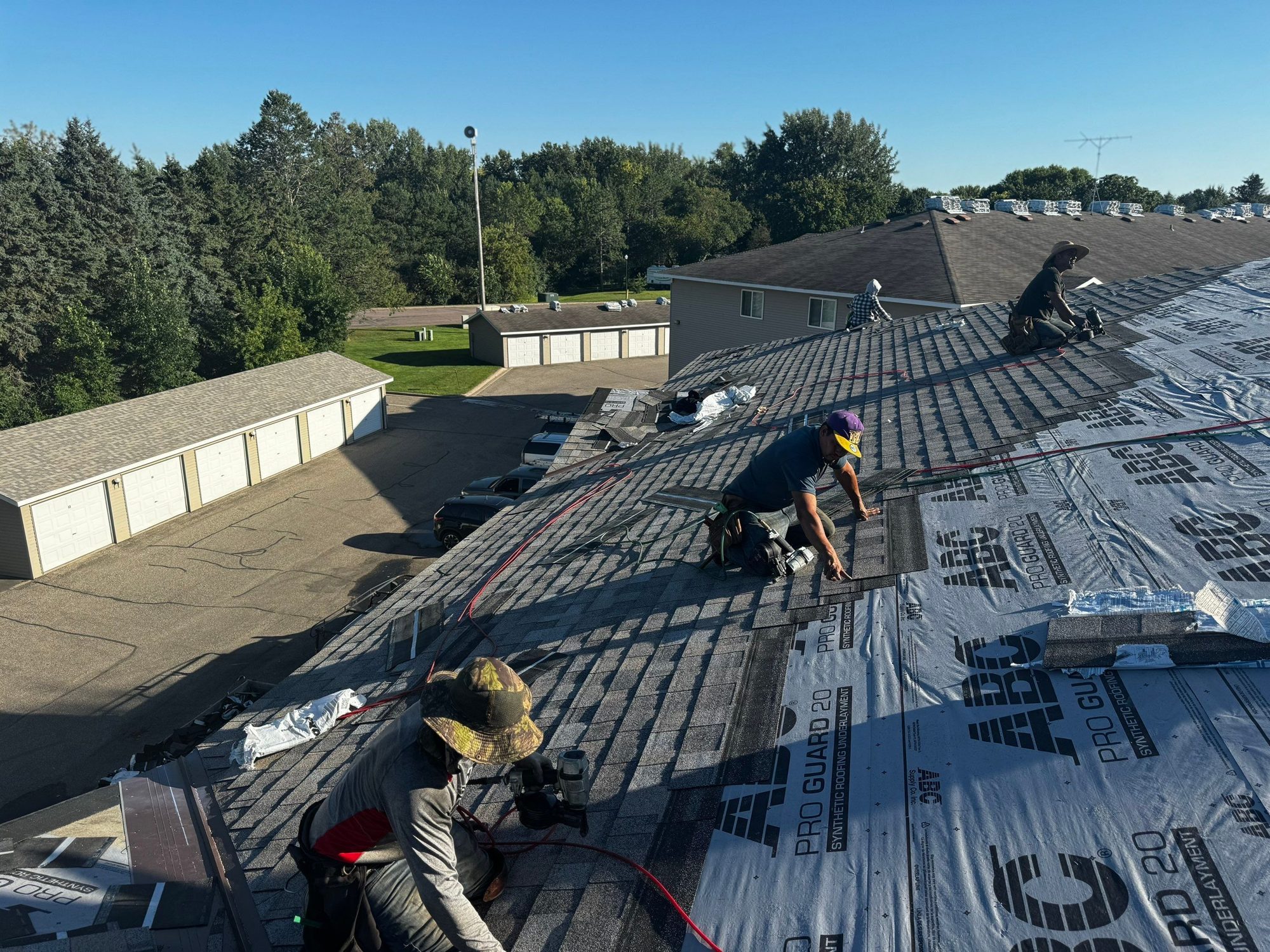 Repair King crew replacing the roof on a Twin Cities multi-family building with garages below