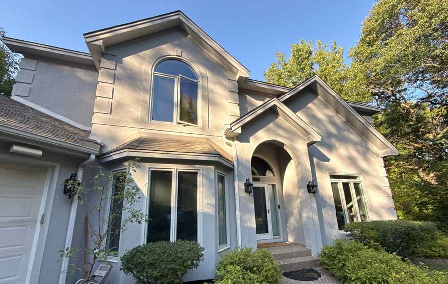 Two-story stucco home with a multi-gable roof in Minnetonka, MN, photographed during a Repair King hail inspection in September 2025