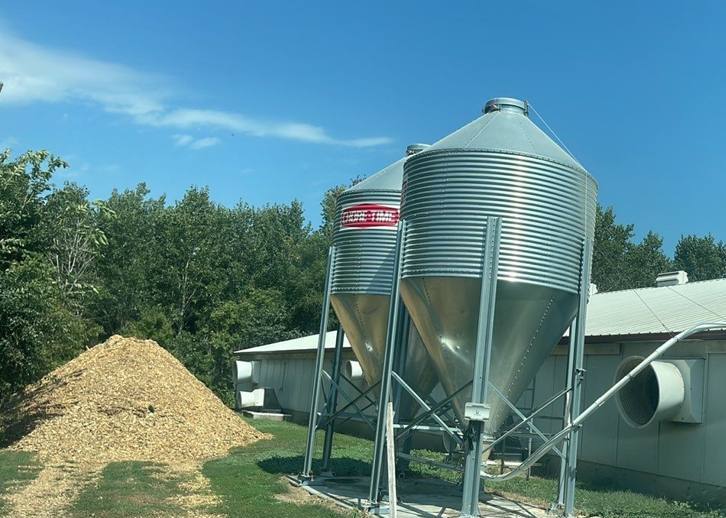 Steel-roofed hog barn and feed bins at a farm on 20th Street SW near Cokato, MN, photographed by Repair King in September 2023