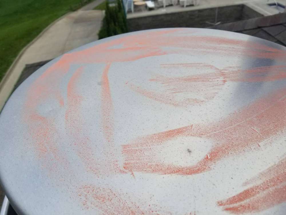 Chalk-highlighted hail dent on a turbine vent cap on the Owatonna Country Club clubhouse roof