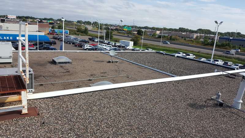 The old gravel roof and roof hatch at Forest Lake Chrysler Jeep Dodge, in Forest Lake, with I-35 traffic in the distance