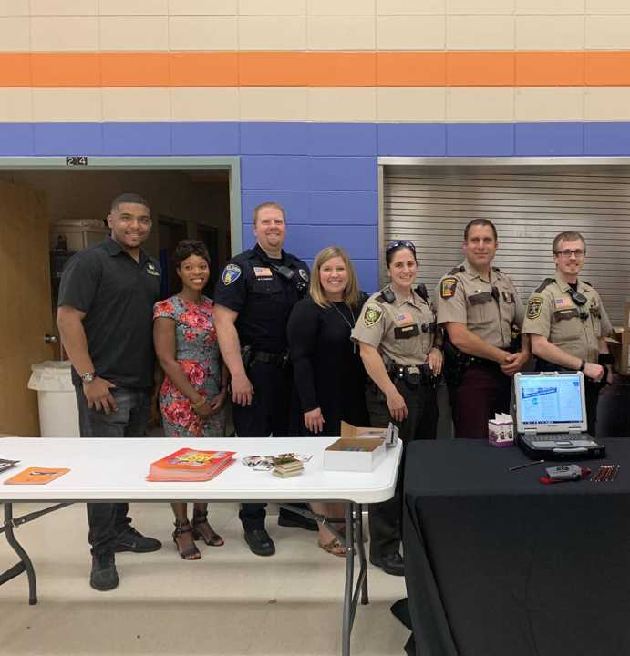 Minnesota State Patrol troopers, officers and volunteers at the State Patrol table during the Talahi backpack giveaway in St. Cloud, MN, August 2019