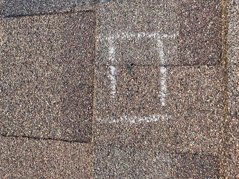 A chalk box marking a hail test square on a Pinecone Villas shingle, Sartell