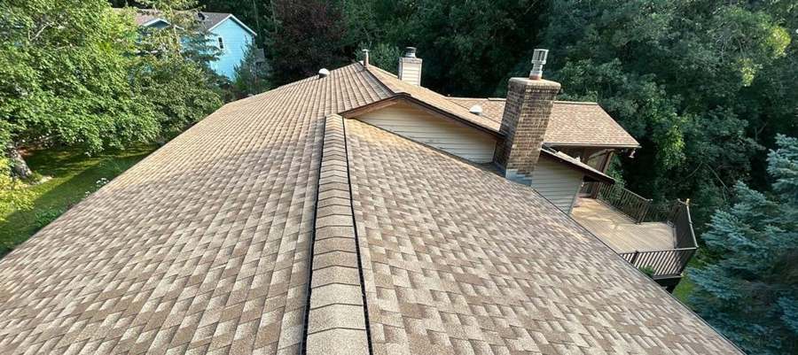 Ridge line and chimney flashing on a Lakeville roof during an inspection, July 2023