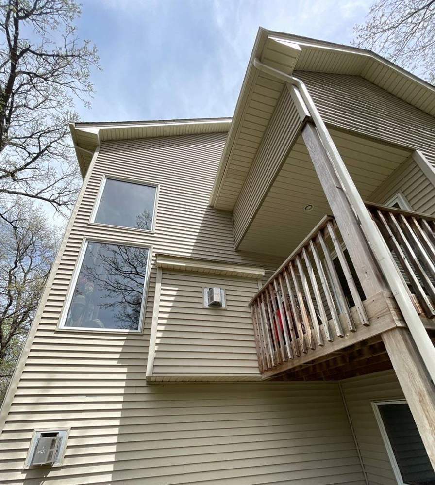 Two-story Big Lake home with deck and satellite dish, viewed during a siding and roof inspection, May 2022