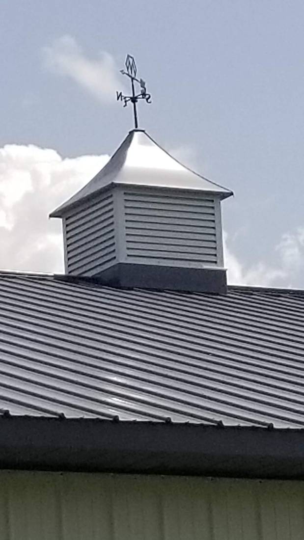 Metal cupola and weathervane on a steel barn roof near Blue Earth