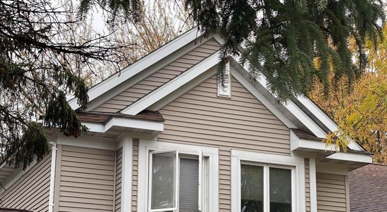 Front gable, siding and windows of a two-story home in Wyoming, MN, photographed during a Repair King storm inspection, October 2021