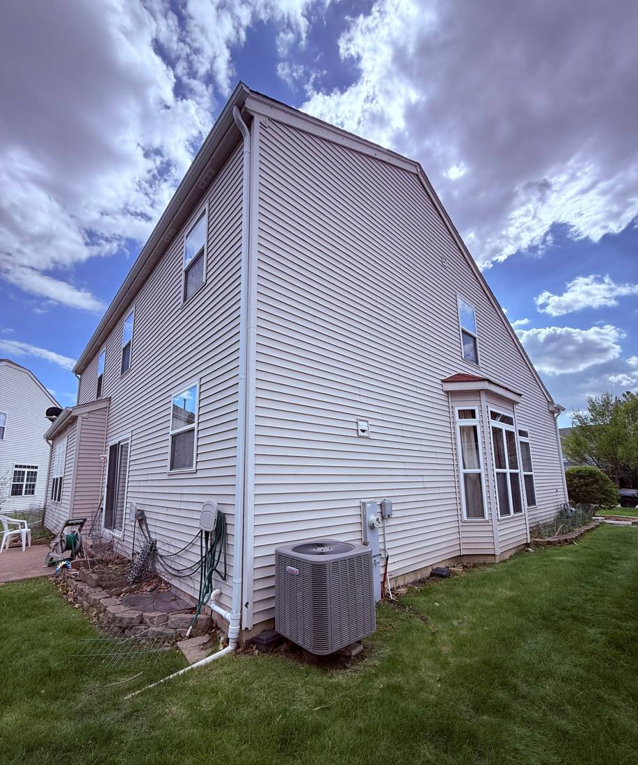Rear elevation of a Bolingbrook townhome with AC unit and satellite dish, May 2026