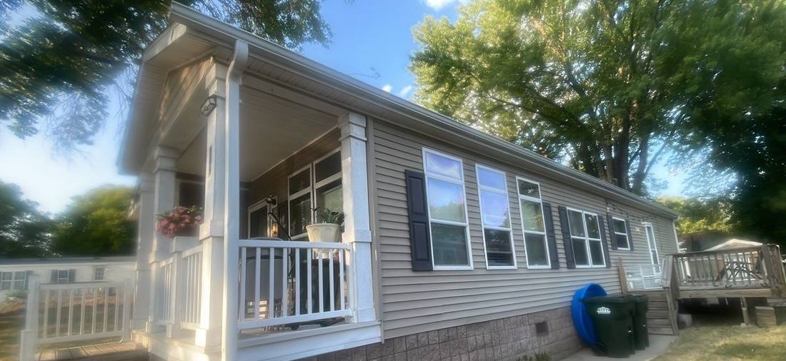 Side view of a vinyl-sided manufactured home with a covered porch in Cimarron, Lake Elmo, MN, during Repair King's July 2023 inspection
