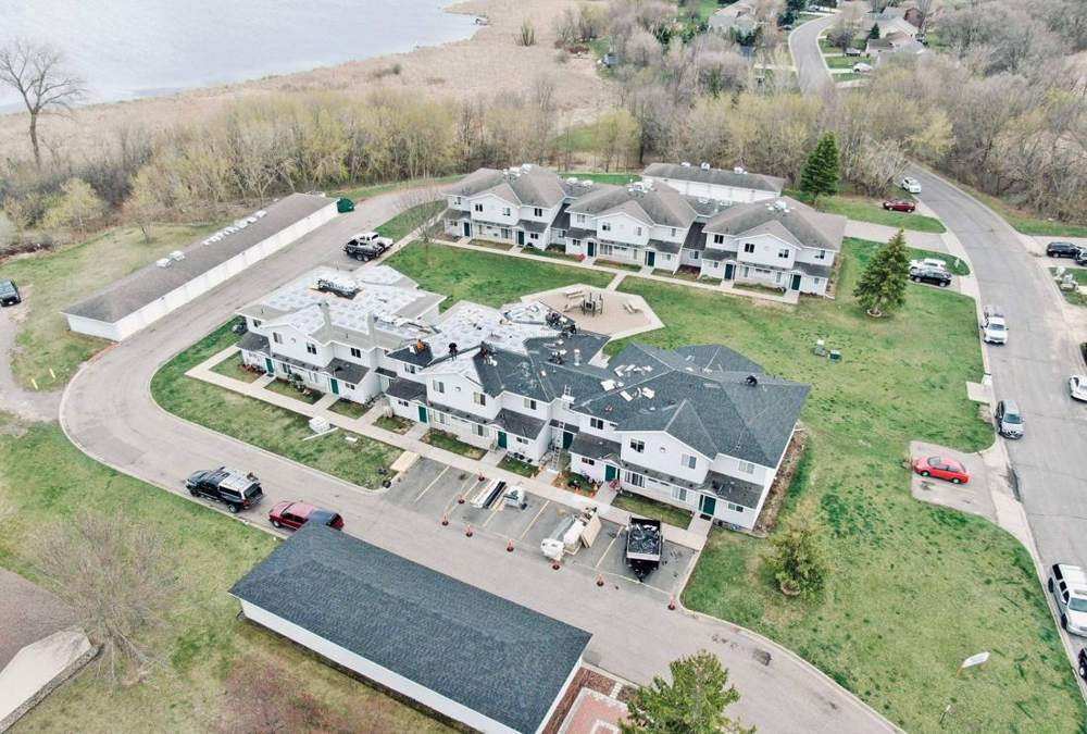 Aerial view of a Circle Pines townhome roof mid-reroof, new synthetic underlayment down, April 2024