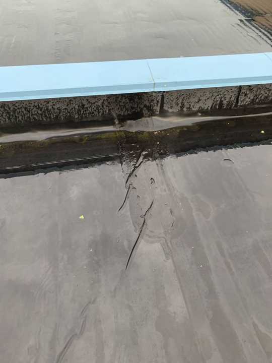 A split in the membrane along the base of the parapet on the Pine City dealership roof, July 2019